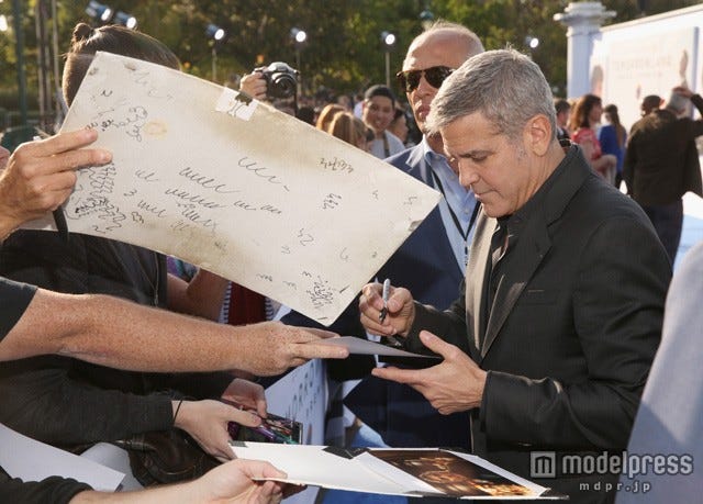 サインに応じるジョージ(C)2015 Disney Enterprise,inc.All Rights Reserved.