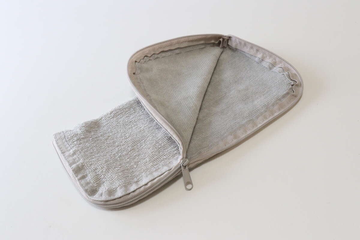 セリアのタオル地ポーチ　スモーキーカラーのチャックを開く