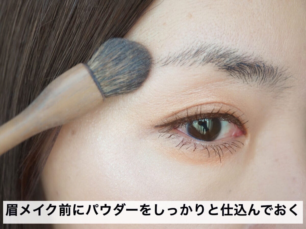 眉メイク前にフェイスパウダーをブラシで眉周りに仕込む様子