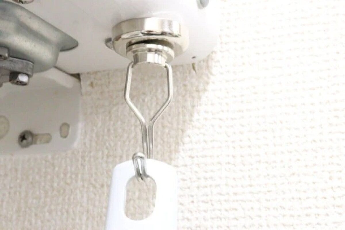 白い棚の底面にネオジム磁石スイングフックが取り付けられている 白い棚の底面にネオジム磁石スイングフックが取り付けられている