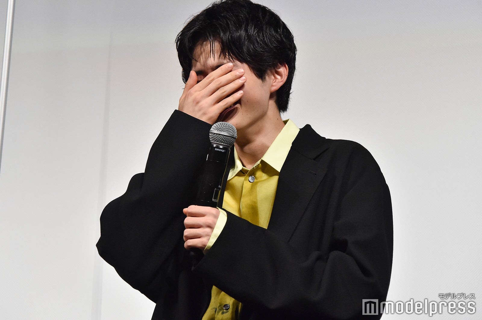 顔を隠して笑う鈴鹿央士 （C）モデルプレス