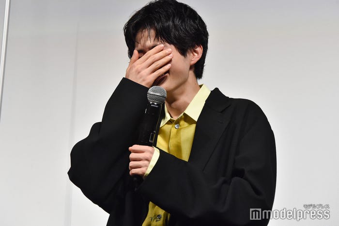 顔を隠して笑う鈴鹿央士 (C)モデルプレス