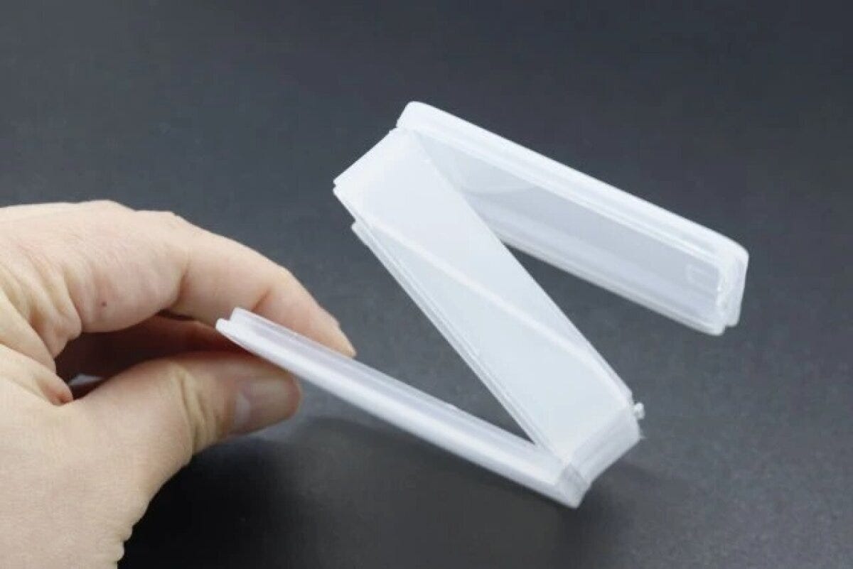 手が両面開いたアクセサリーケースをZ字型に持っている