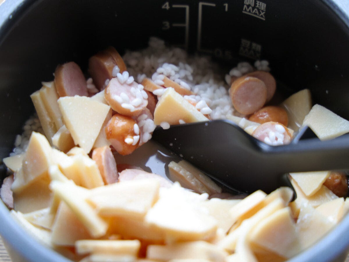 炊飯器にたけのことソーセージを入れて混ぜる工程