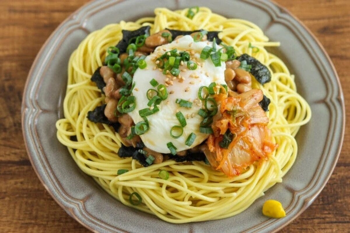 キムチがトッピングされたポーチドエッグと納豆の和風パスタ