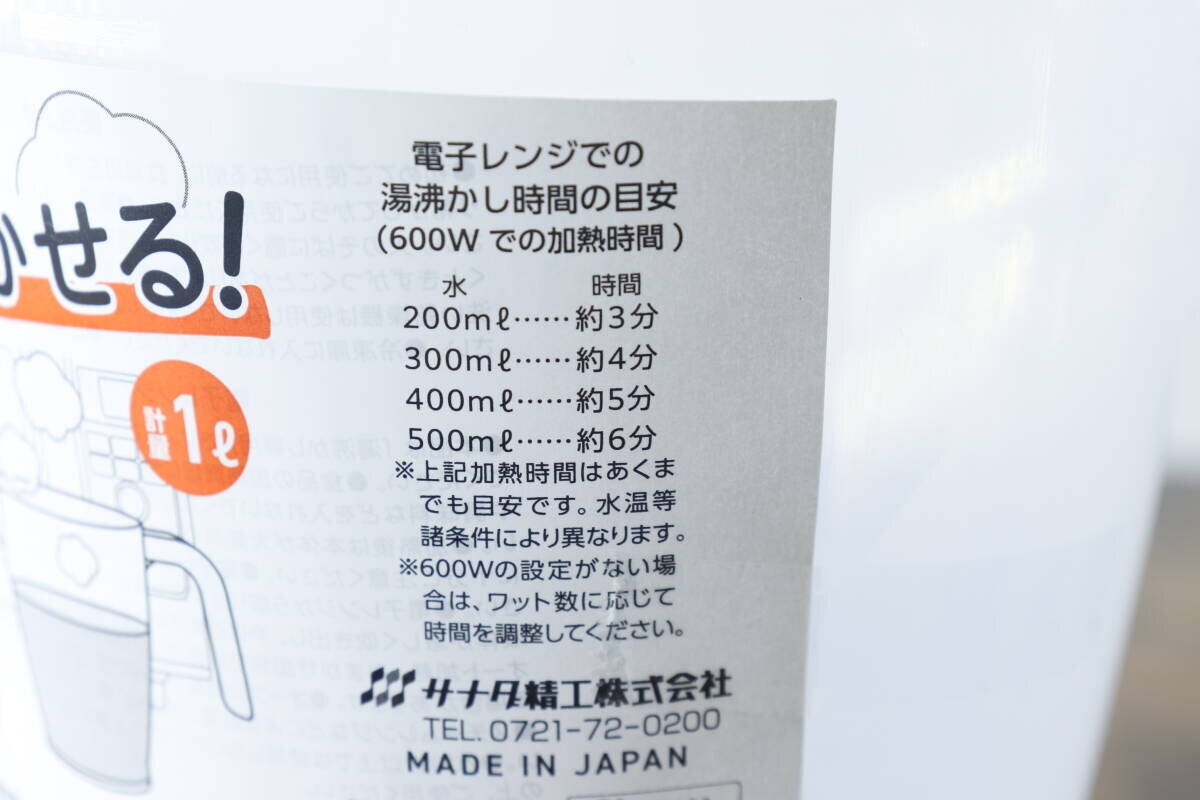 計量カップに貼られた商品パッケージの電子レンジでの湯沸かし時間の目安が書かれた部分のアップ 計量カップに貼られた商品パッケージの電子レンジでの湯沸かし時間の目安が書かれた部分のアップ