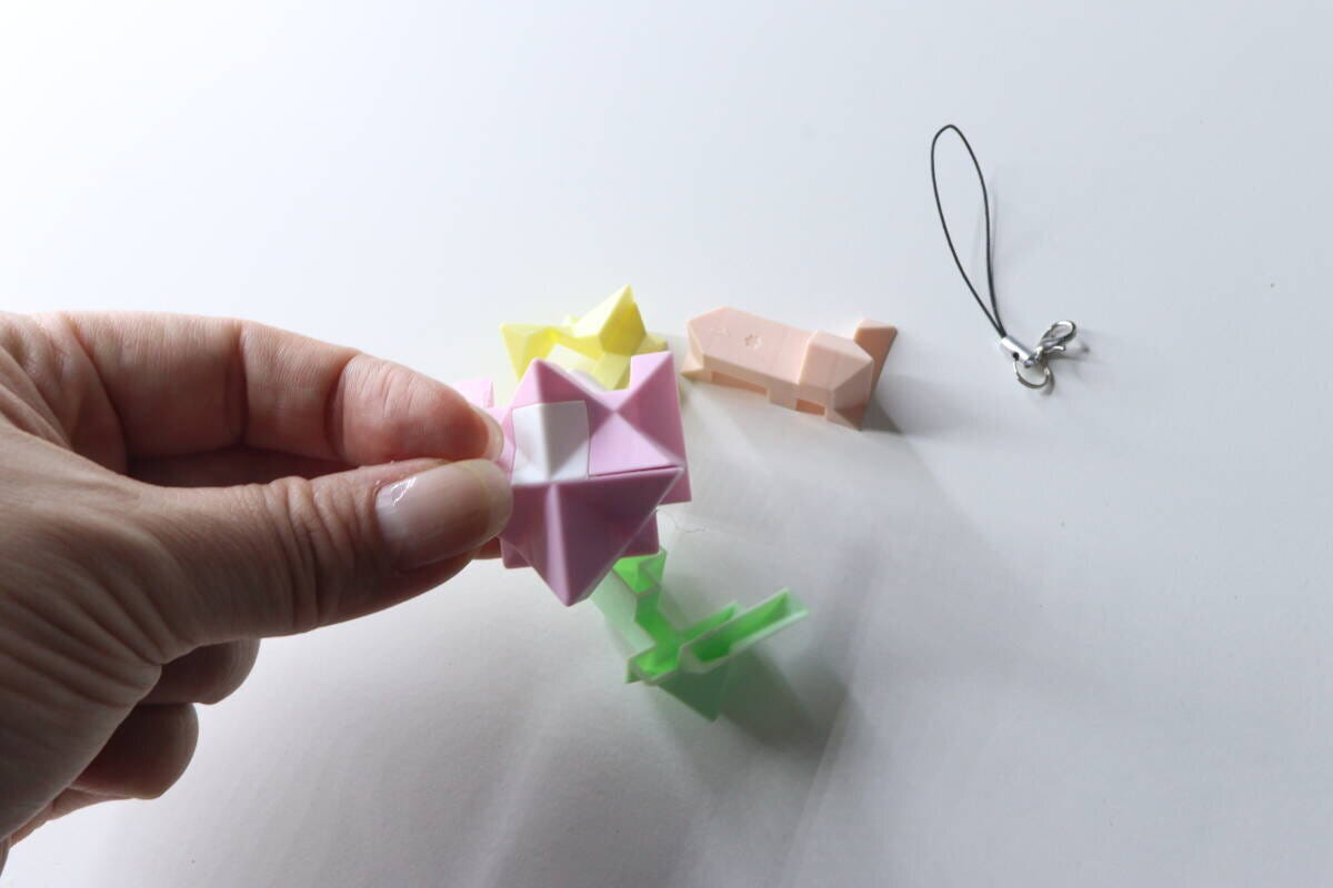 女性が分解されたパズルパーツを手に持ち、組み立てようとしている様子