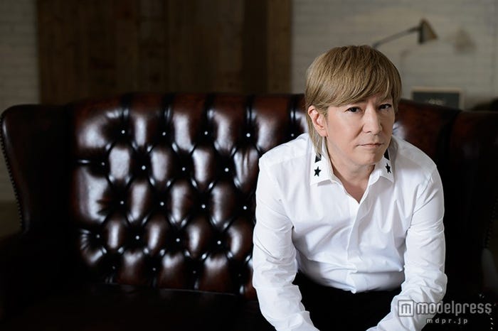 ジバンシーの白シャツとディオールのパンツを着こなしている小室哲哉