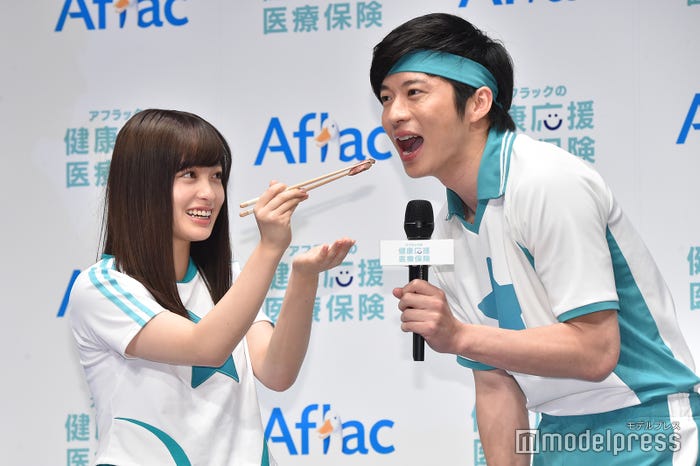 “あ~ん”を待ち構える田中圭(右)を見つめる橋本環奈(左)/(C)モデルプレス