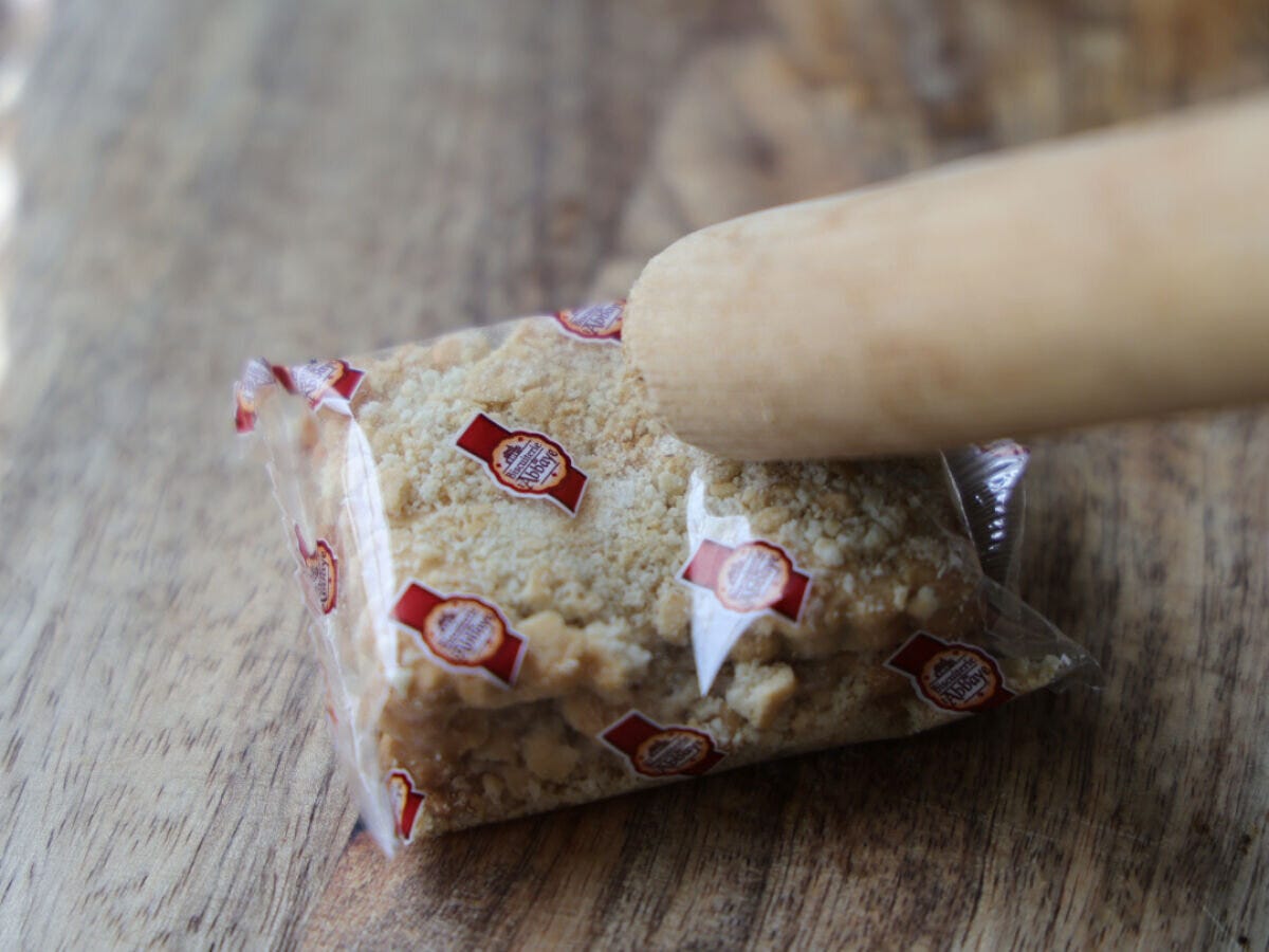 クッキーの袋の上から麺棒で叩き、細かく砕いている作業の様子