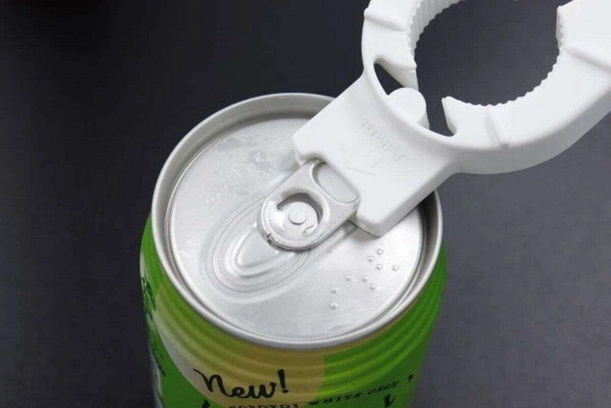 白い多機能オープナーで緑色の缶のプルトップを開けようとしている様子 白い多機能オープナーで緑色の缶のプルトップを開けようとしている様子