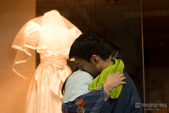 買えないウエディングドレスの前でサキを抱きしめる大介(C)2014『振り子』製作委員会