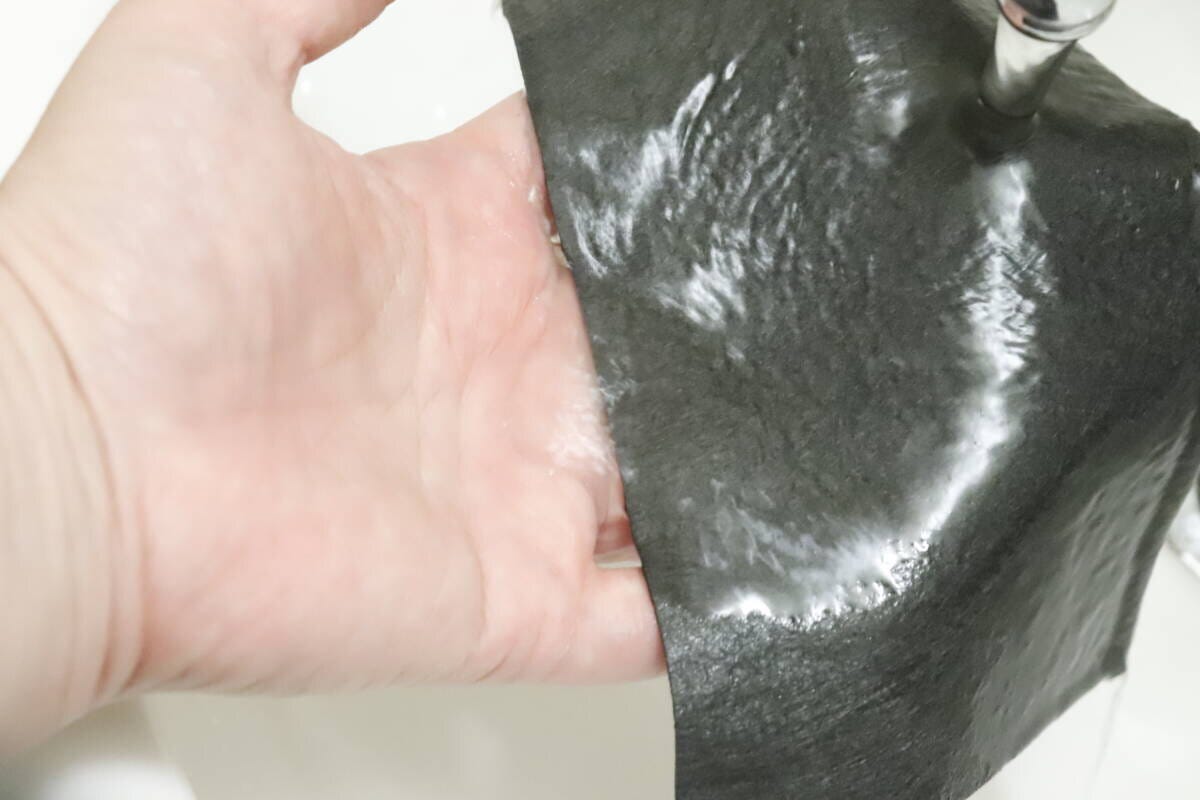 手でマイクロファイバークロスを水で濡らしている様子