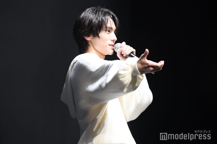 森愁斗が携帯を差し出してくれたときの再現をする山下幸輝(C)モデルプレス