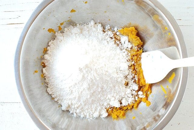 潰したかぼちゃにホットケーキミックスを入れ、ヘラで押し付けるようにして全体を混ぜ合わせる。 潰したかぼちゃにホットケーキミックスを入れ、ヘラで押し付けるようにして全体を混ぜ合わせる。