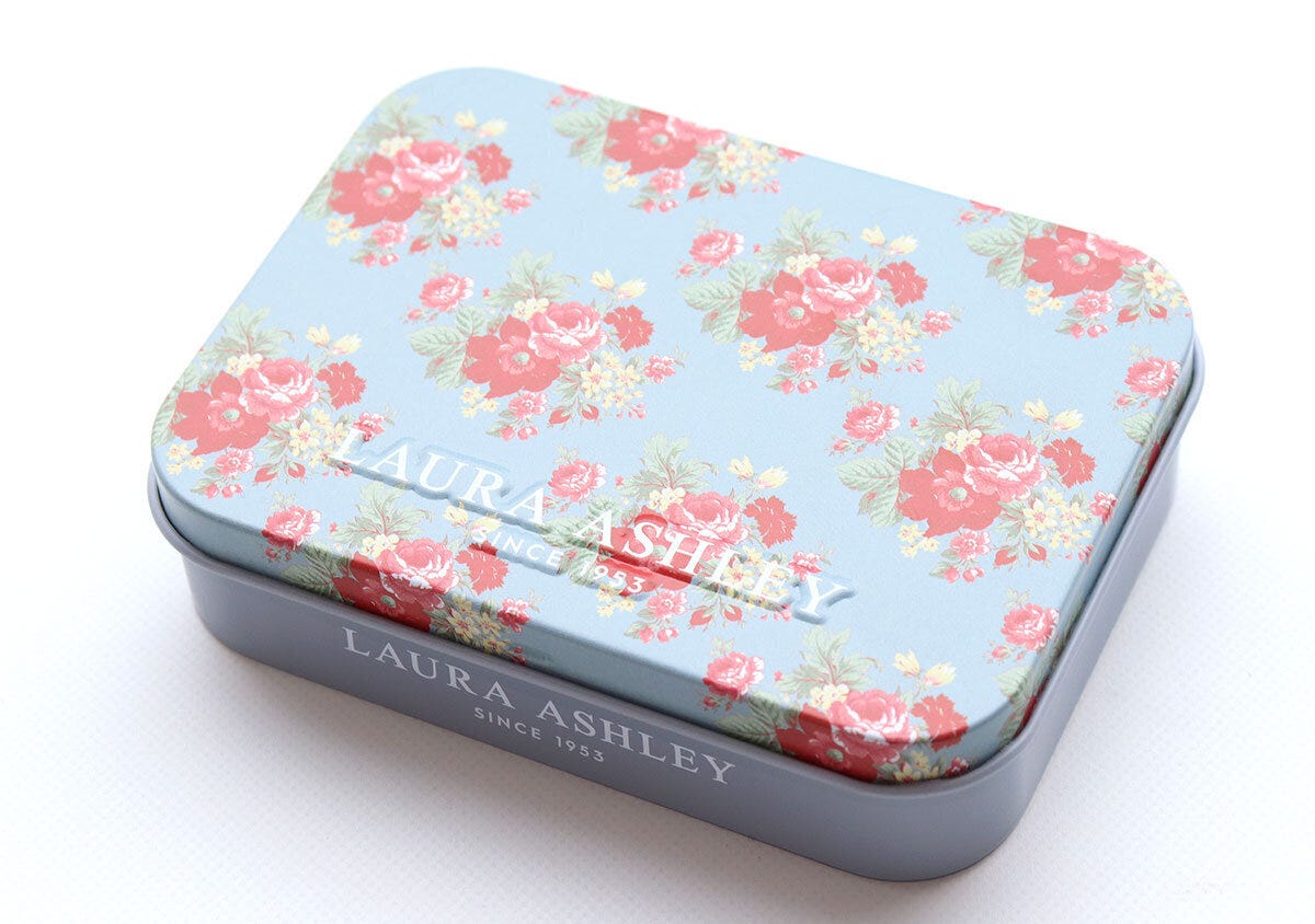 華やかなローズ柄が描かれ立体的なロゴが入ったブルーの缶ケース 華やかなローズ柄が描かれ立体的なロゴが入ったブルーの缶ケース