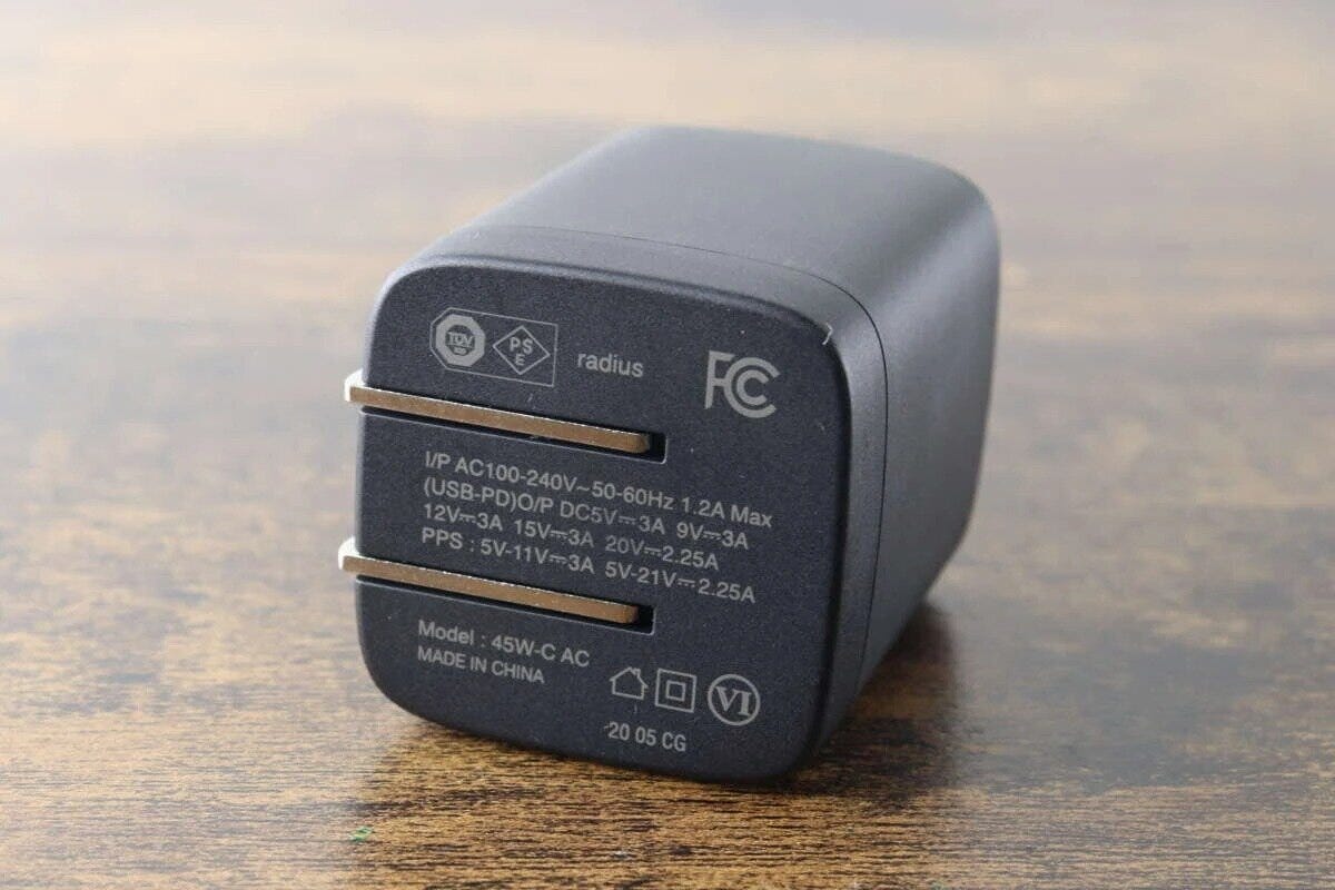 折り畳みプラグと製品仕様の文字が記載された黒い充電器の底面