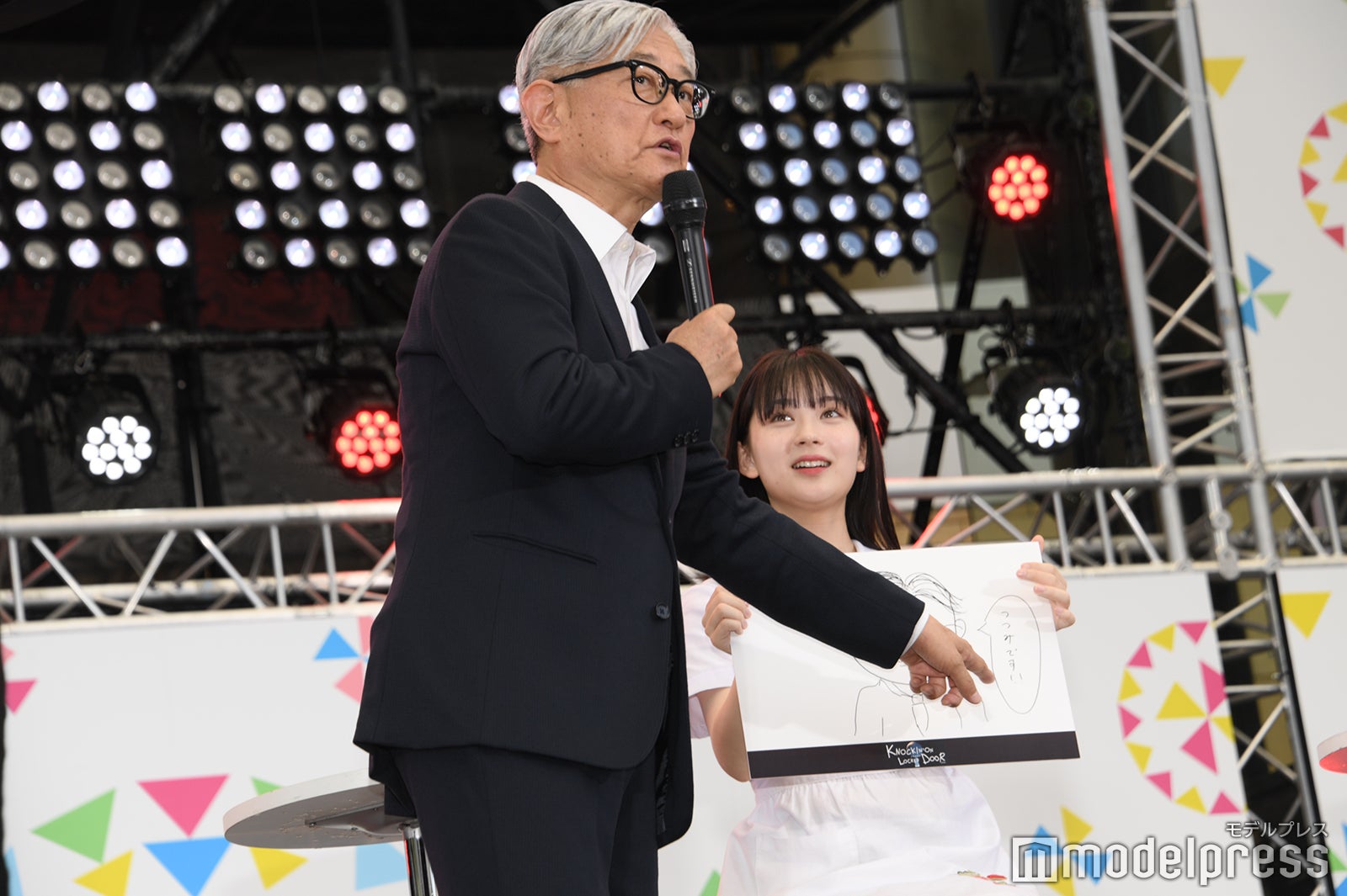 畑芽育の似顔絵に記された「つつみです」をツッコむ堤幸彦監督（C）モデルプレス