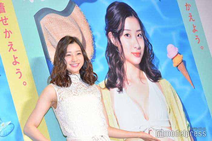 “奇跡の谷間”ができたポスタービジュアルをバックに撮影する足立梨花(C)モデルプレス