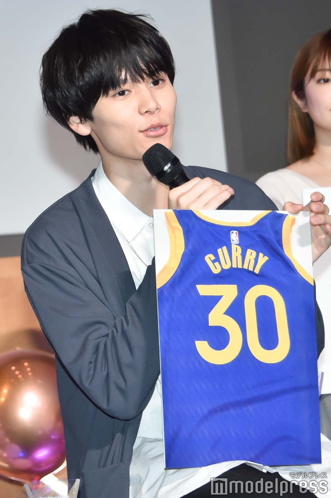 バスケ＆サッカー選手のユニフォームに囲まれて寝ている萩原利久（C）モデルプレス