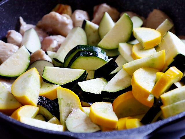 鶏肉にズッキーニと茄子を加えて炒める