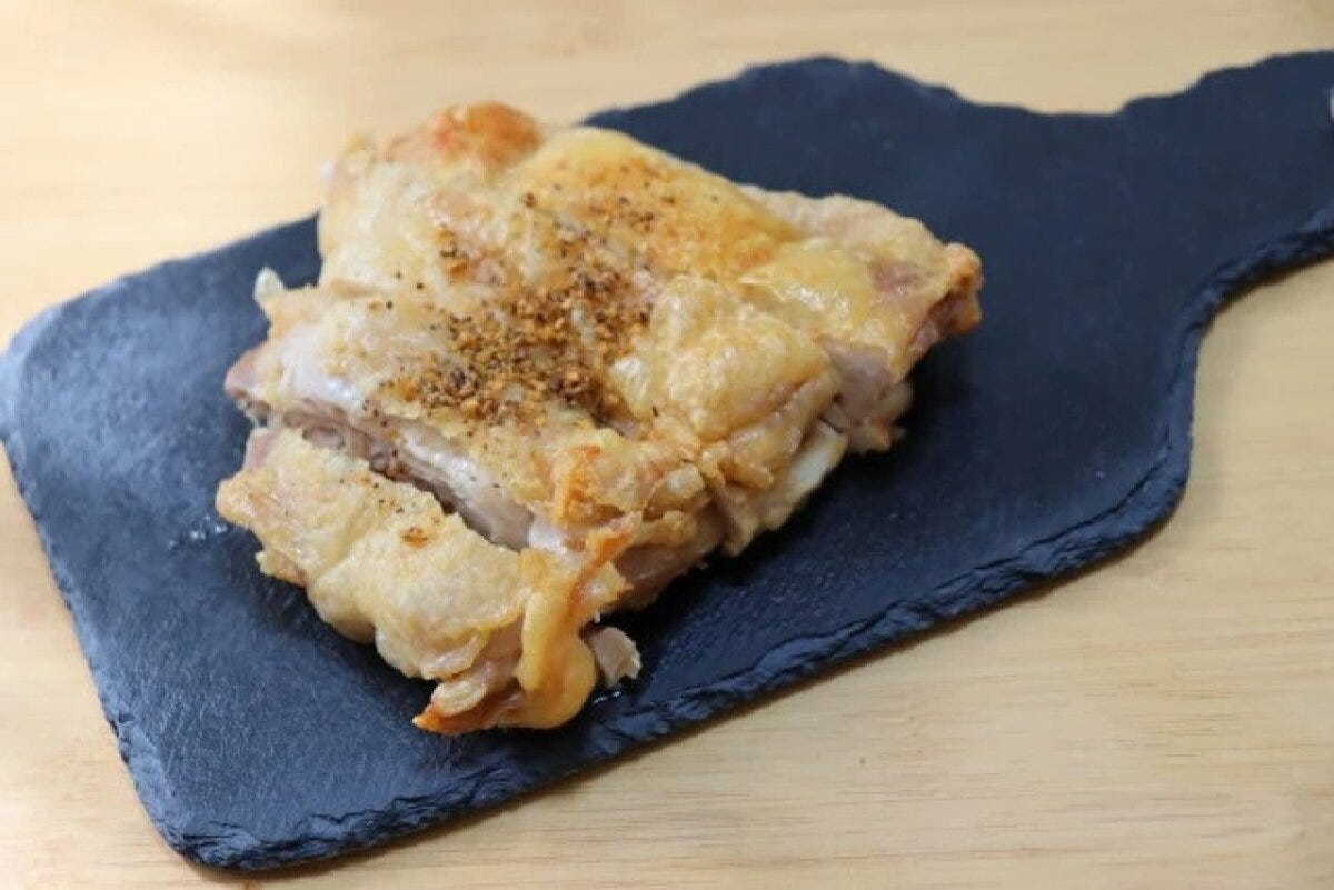 黒いスレートプレートに鶏肉のグリルが盛り付けられている 黒いスレートプレートに鶏肉のグリルが盛り付けられている