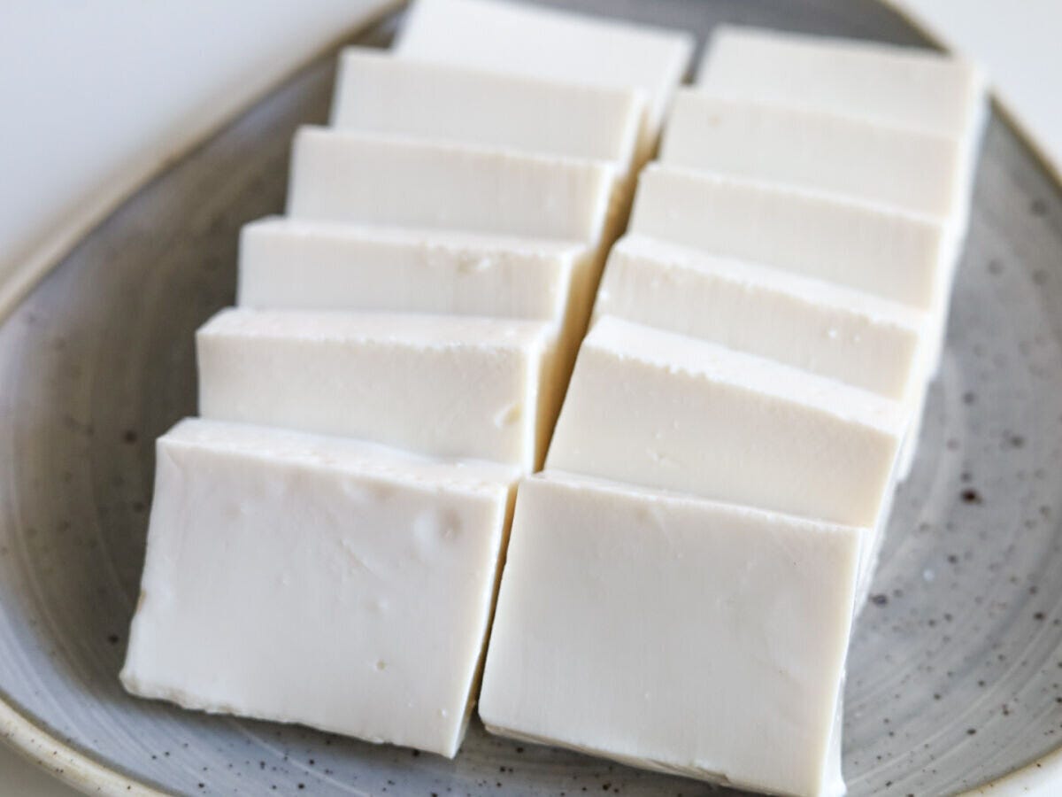 灰色のお皿に、一口大にカットされた白い絹ごし豆腐が並べられている様子