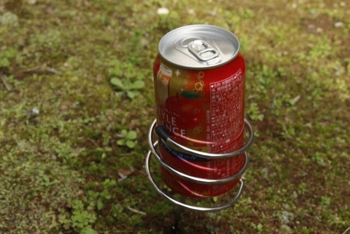 地面に刺さったドリンクホルダーに赤い缶ジュース
