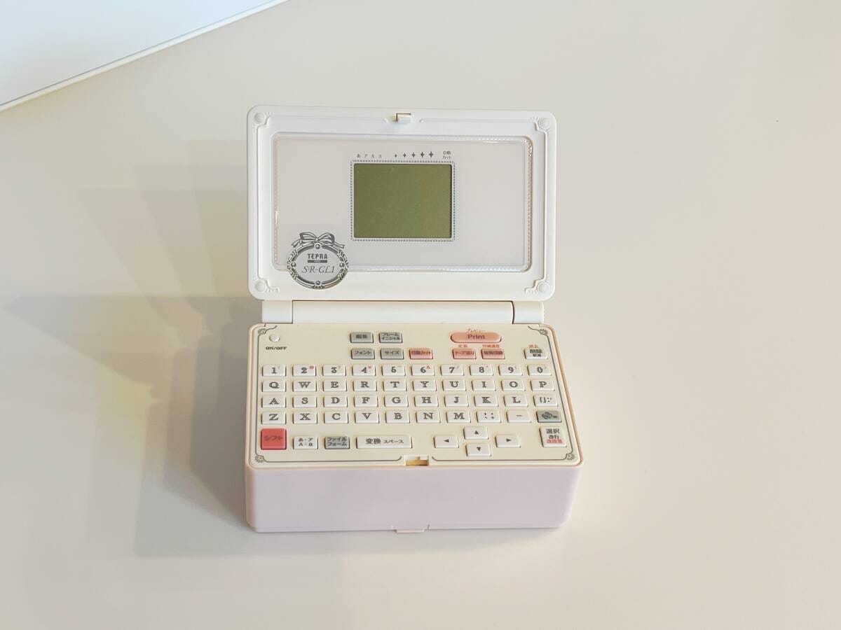 白い机の上に置かれたピンク色のラベルライター 白い机の上に置かれたピンク色のラベルライター