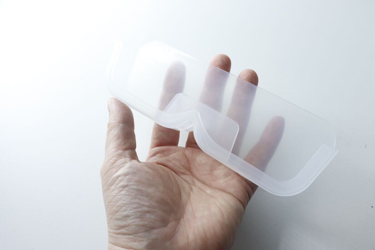 半透明のメガネ収納本体を手のひらに乗せて見せている様子