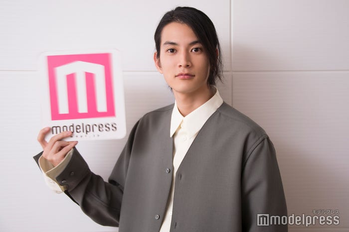 ロゴボードを高速で動かしてカメラマンを翻ろうする渡邊圭祐 (C)モデルプレス