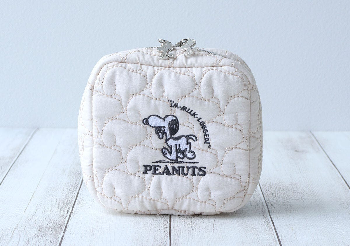 ミルク瓶をくわえたスヌーピーの刺繍が入った白いキルティングポーチ