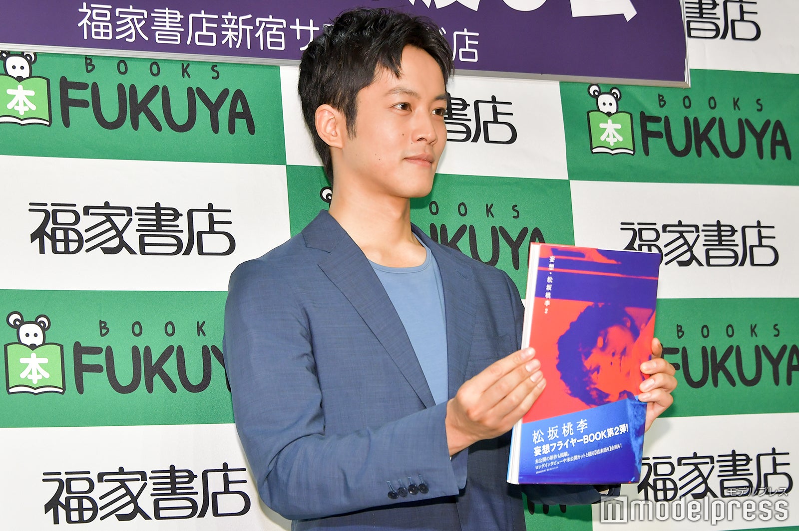 「本を前に押し出す感じで」というリクエストに応じる松坂桃李 （C）モデルプレス