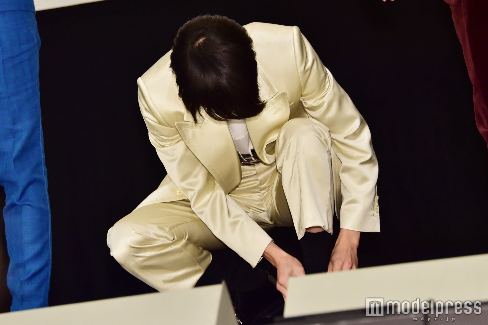 靴紐を結び直す菅田将暉 （C）モデルプレス