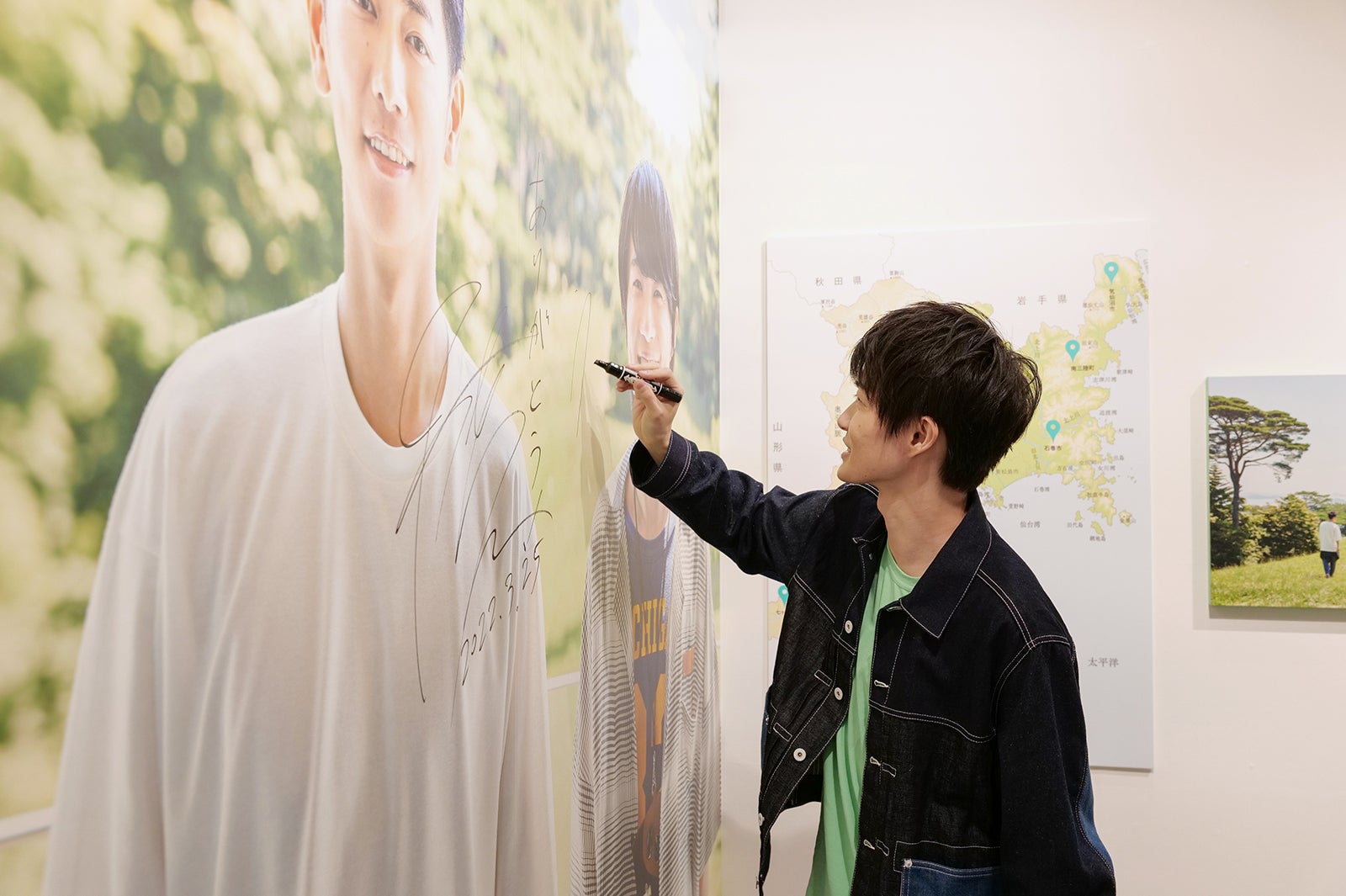 来場した記念として大型パネルにサインをする神木隆之介（提供写真）