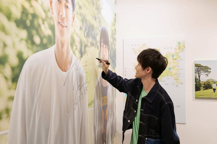 来場した記念として大型パネルにサインをする神木隆之介(提供写真)