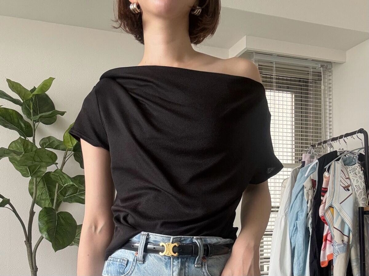 女性が黒のドレープネックTをワンショルダーで着用