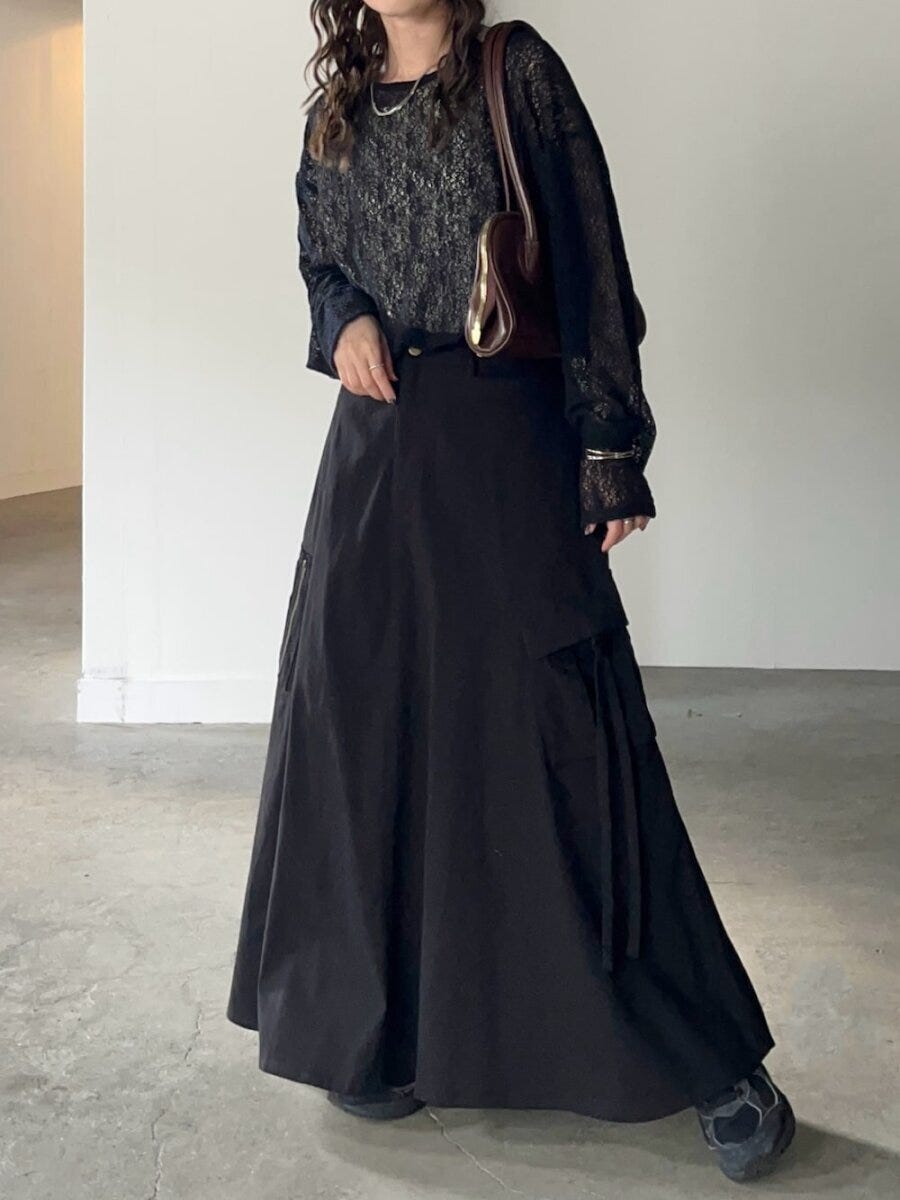 黒の透け感レーストップスとロングカーゴスカートを着用した女性 黒の透け感レーストップスとロングカーゴスカートを着用した女性