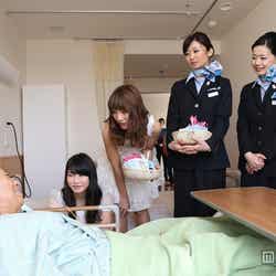 入院している患者へ「すずらんの花」を贈呈したAKB48(左から:横山由依、高城亜樹)とANA客室乗務員