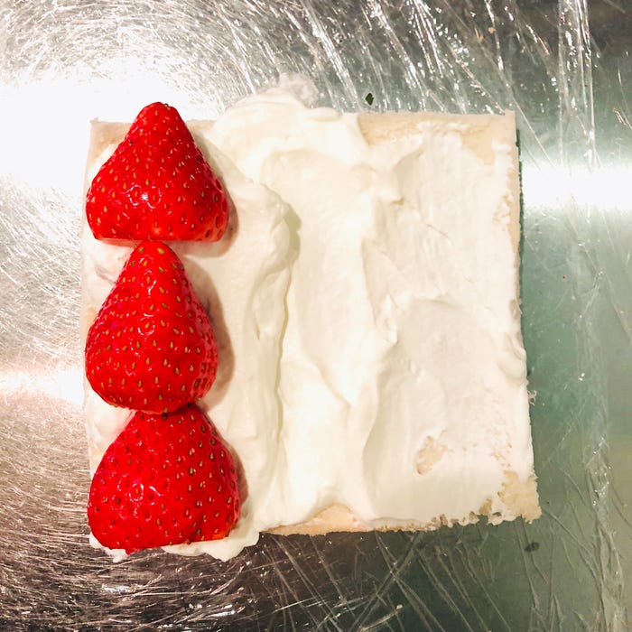 手順2:1枚だけ手前に少し多めに生クリームを塗りいちごを横に並べる/画像提供:柏原歩