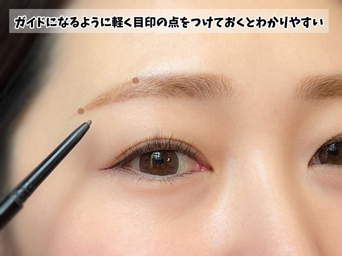アイブロウペンシルで眉に目印の点をつける様子