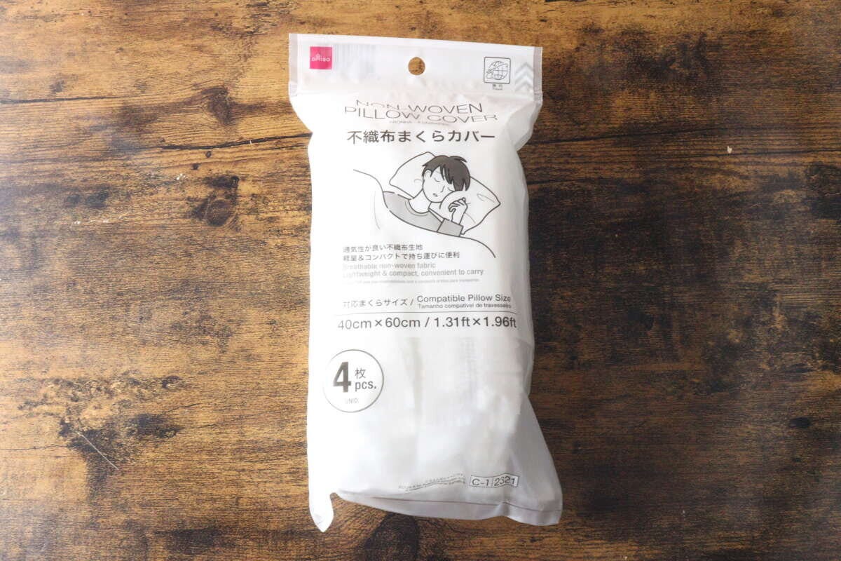 木目のテーブルに置かれたダイソー不織布まくらカバーのパッケージ