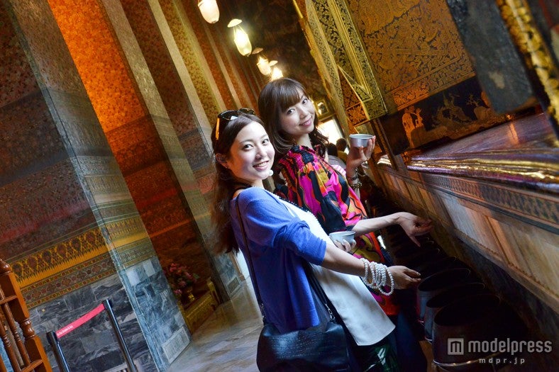 108つの鉢ひとつひとつにサタン硬貨を入れていく／モデル：百々さおり、富田千穂