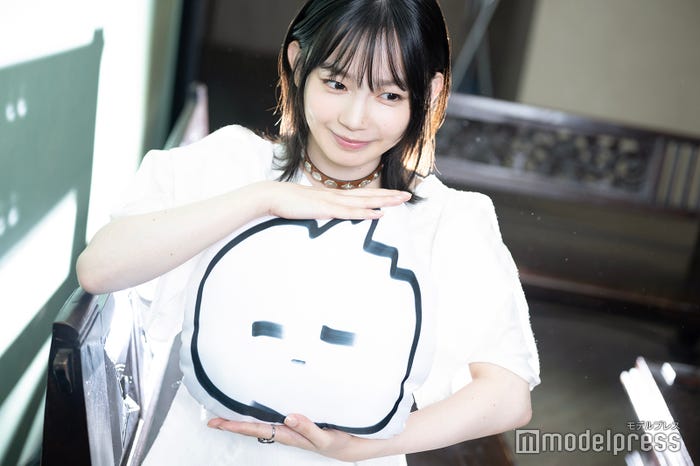 自身作のイラスト“とがるくん”のクッションを持つ宮崎優(C)モデルプレス