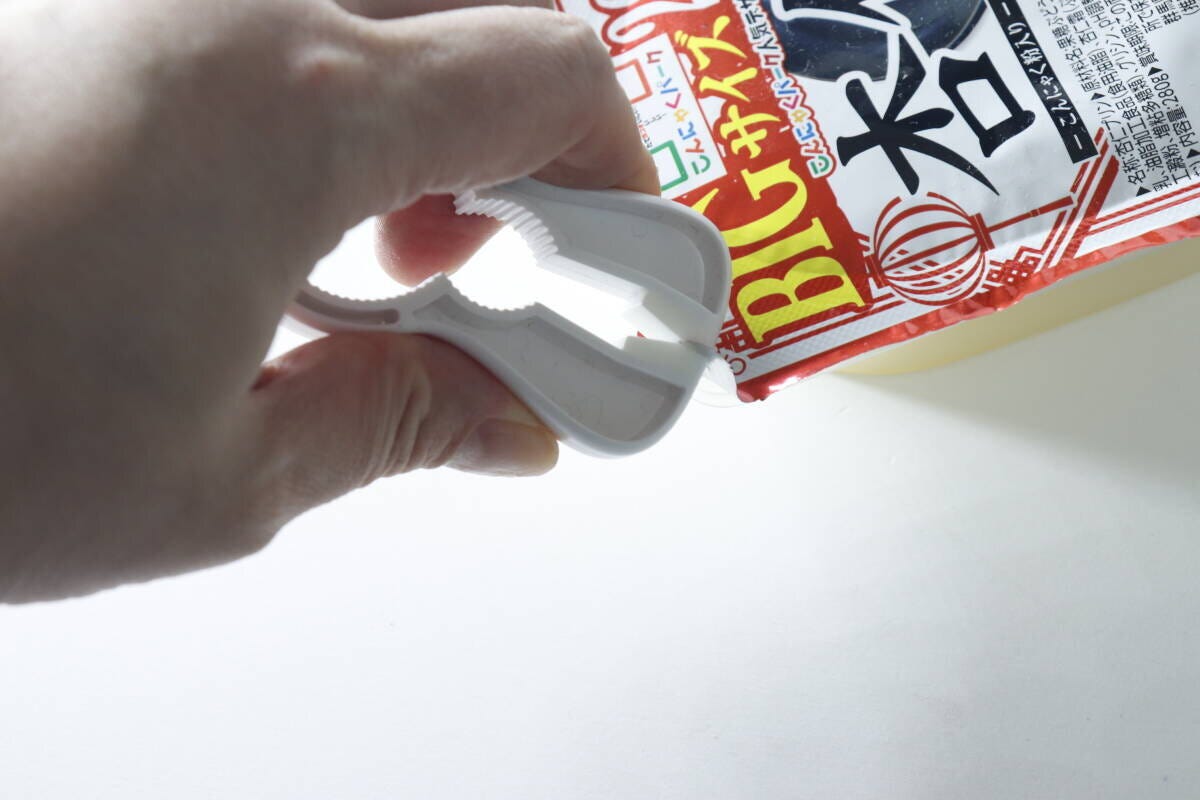 4WAYキャップオープナーで袋の圧着フィルムを挟んで開けている様子
