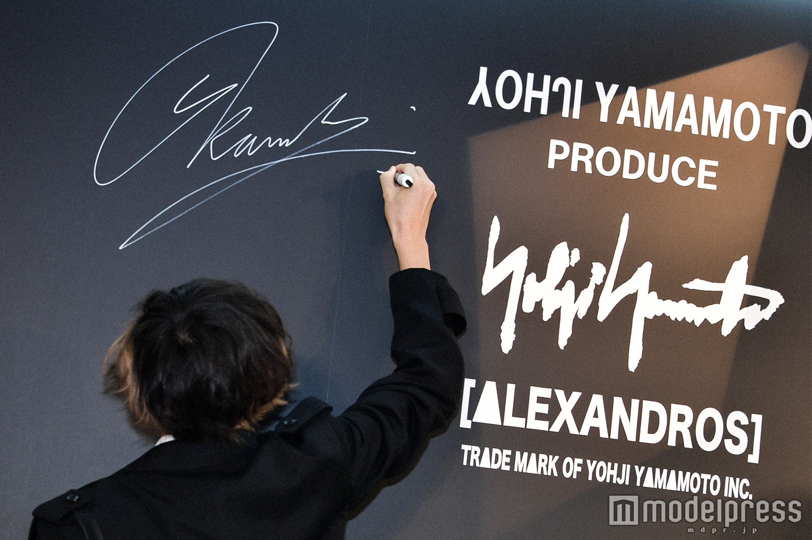 ポップアップショップ内の壁にサインをする川上洋平 （C）モデルプレス