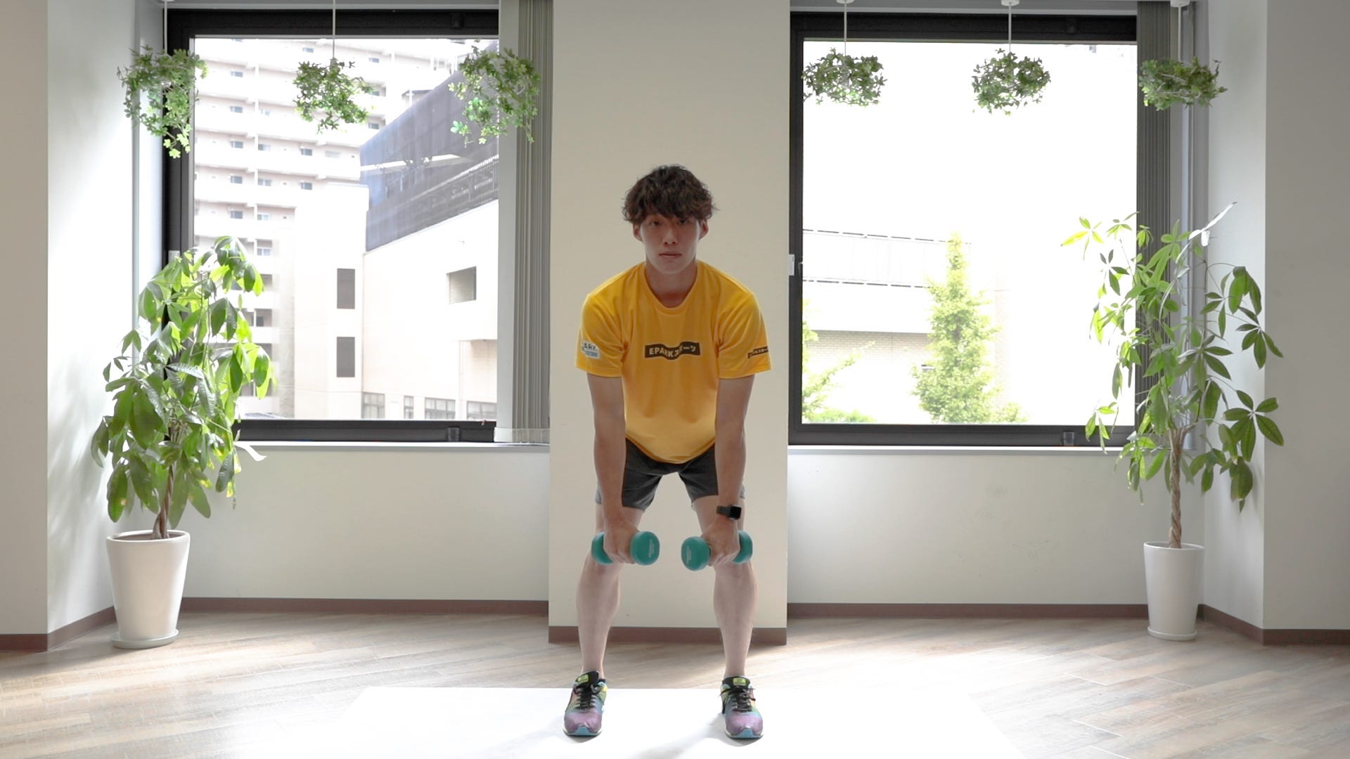 上体を前に倒して胸を張り、両手でダンベルを持っている図