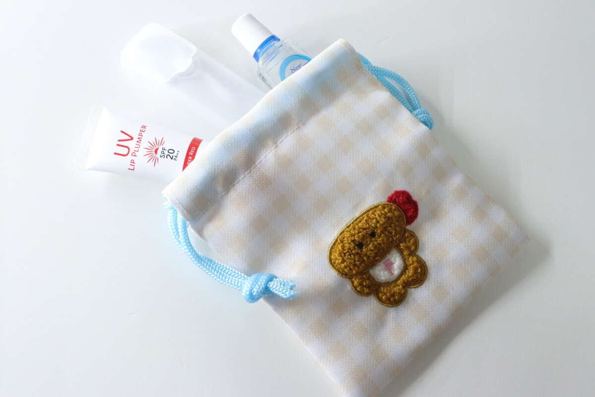 ダイソーのサガラ刺繍プチ巾着に目薬、リップ、デンタルピックを入れた状態 ダイソーのサガラ刺繍プチ巾着に目薬、リップ、デンタルピックを入れた状態