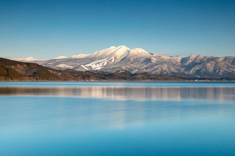 雪化粧の秋田駒ケ岳と田沢湖／写真素材ぱくたそ
