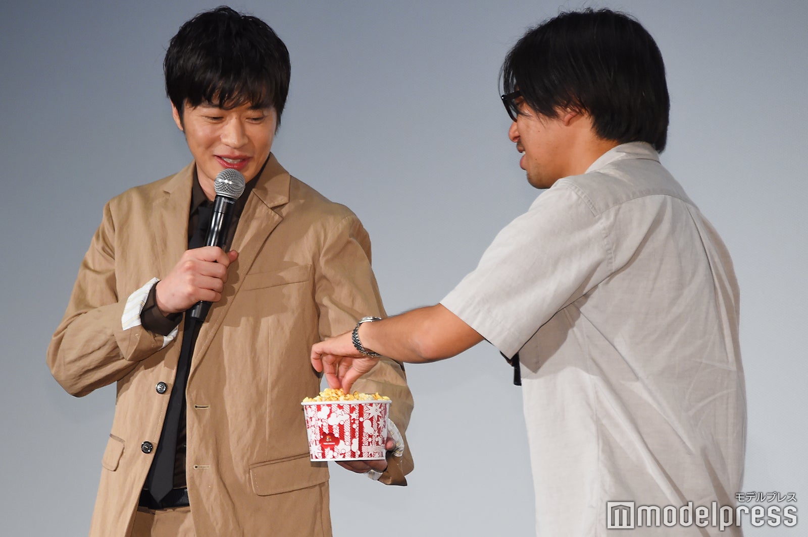 瑠東東一郎監督（右）にポップコーンをわけてあげる田中圭（左）／（C）モデルプレス